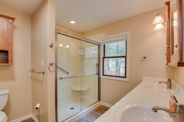 bathroom with tile patterned floors, vanity, toilet, and walk in shower