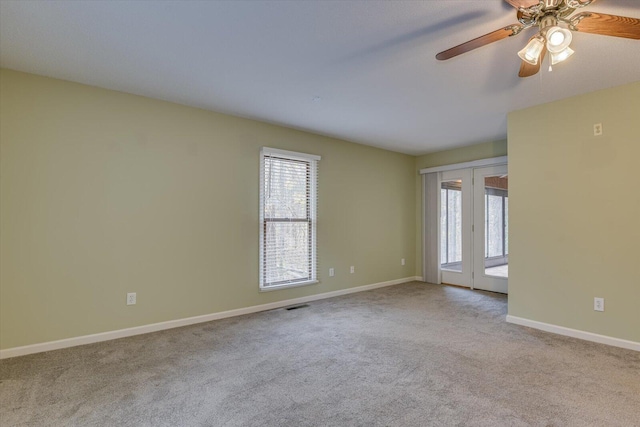 carpeted spare room featuring ceiling fan