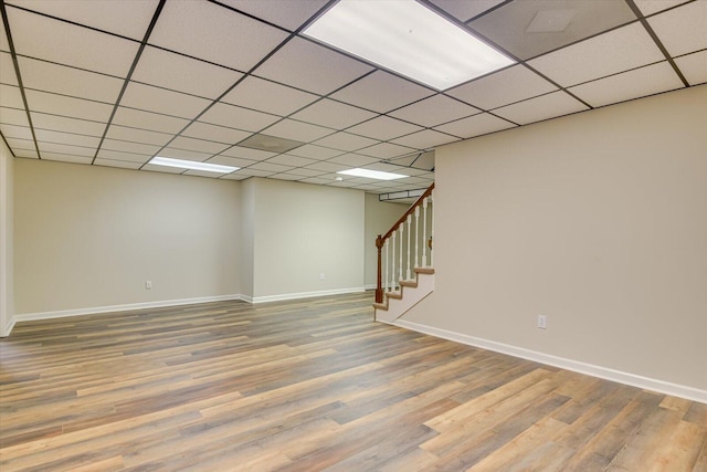 basement featuring a paneled ceiling and wood-type flooring