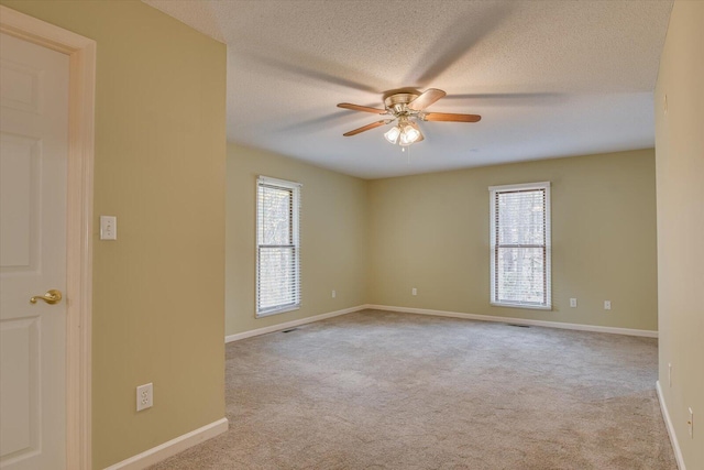 carpeted spare room featuring ceiling fan and a textured ceiling