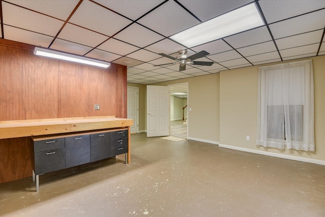 basement featuring a paneled ceiling and ceiling fan