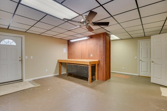 basement featuring ceiling fan and a drop ceiling