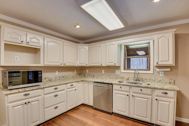 kitchen with light stone countertops, stainless steel appliances, crown molding, and sink