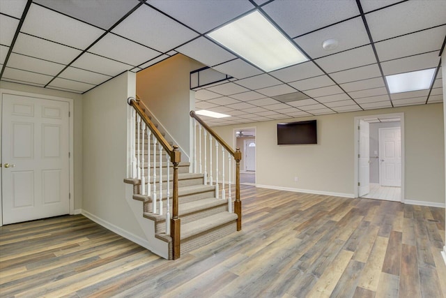 interior space featuring wood-type flooring and a drop ceiling