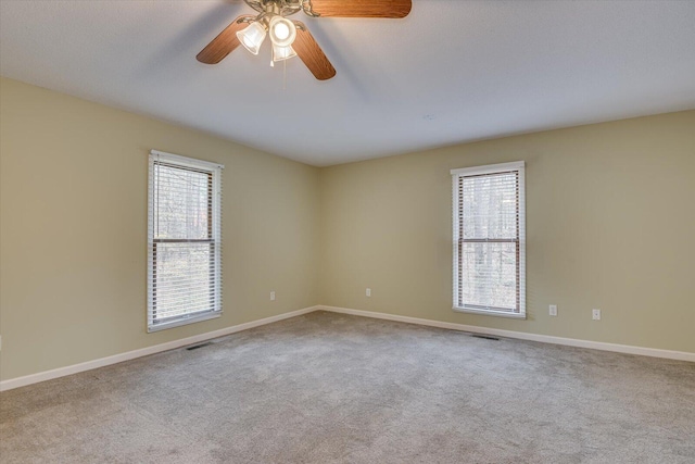 unfurnished room with ceiling fan, a healthy amount of sunlight, and light colored carpet