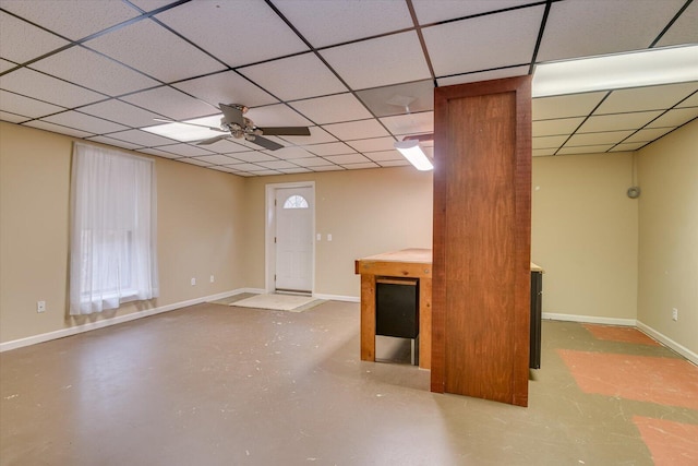 basement featuring a paneled ceiling and ceiling fan