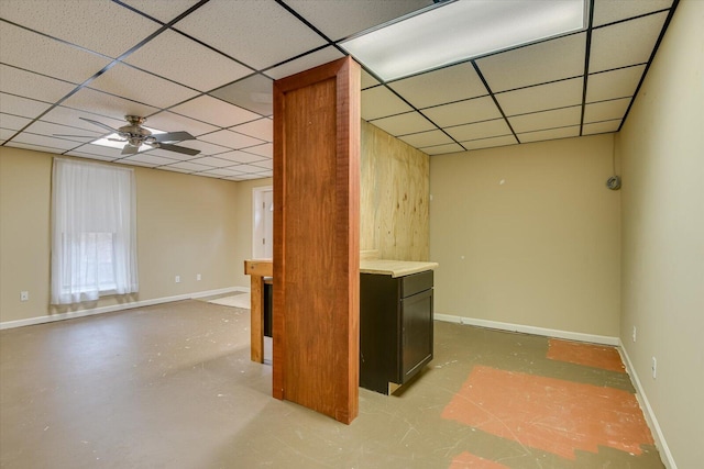 basement featuring a drop ceiling and ceiling fan