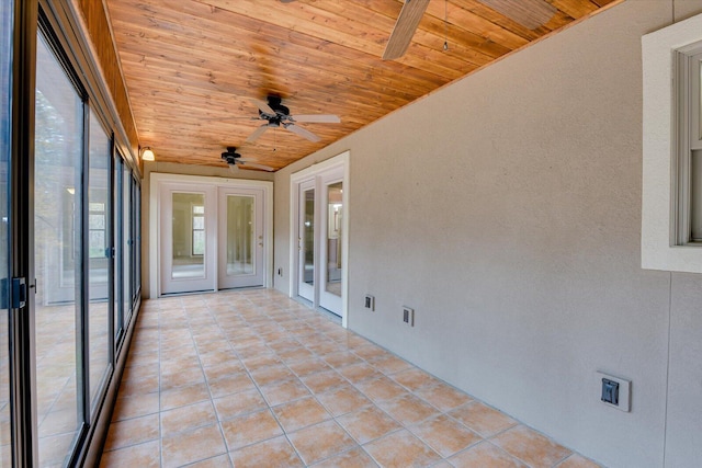 unfurnished sunroom featuring french doors, ceiling fan, and wooden ceiling