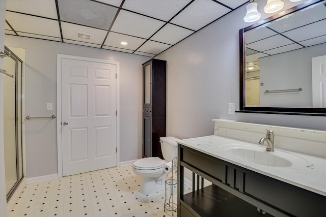 bathroom featuring a paneled ceiling, vanity, toilet, and an enclosed shower