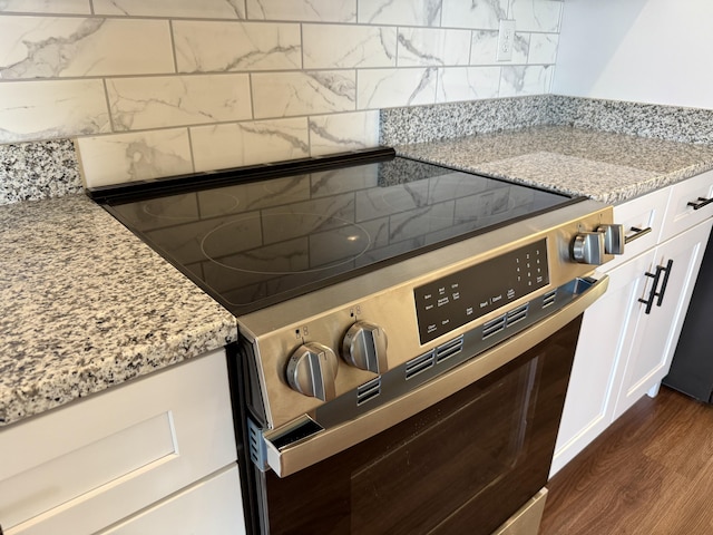 213 Whiskey Rd, Grovetown, GA 30813 - kitchen featuring backsplash, white cabinetry, light stone countertops, dark wood finished floors, and electric range