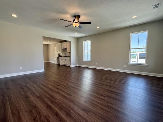 213 Whiskey Rd, Grovetown, GA 30813 - unfurnished living room with dark wood-style flooring, a wealth of natural light, and a ceiling fan