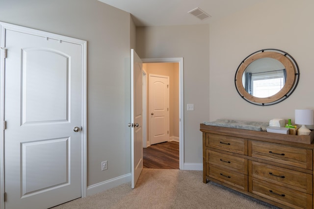 bedroom with light carpet, visible vents, and baseboards