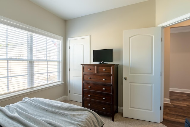 bedroom with light carpet and baseboards