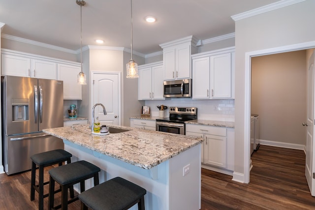 kitchen featuring tasteful backsplash, appliances with stainless steel finishes, a kitchen breakfast bar, ornamental molding, and a sink