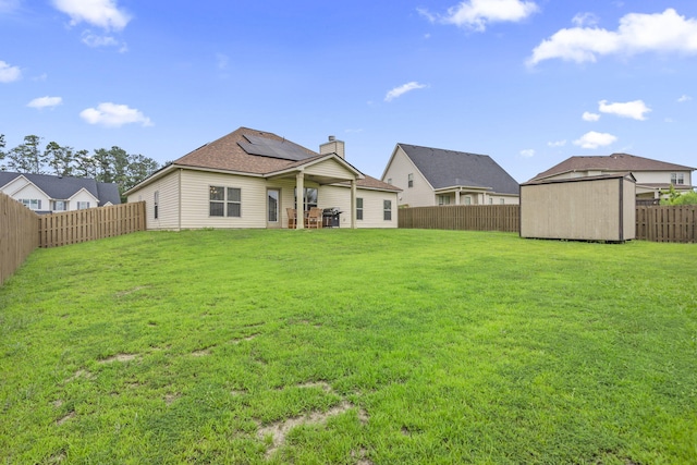 5315 Bull St, Augusta, GA 30909 - rear view of property with a fenced backyard, a storage shed, solar panels, a chimney, and a patio area