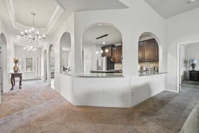 5315 Bull St, Augusta, GA 30909 - kitchen with light carpet, stainless steel fridge, dark brown cabinetry, and light stone countertops