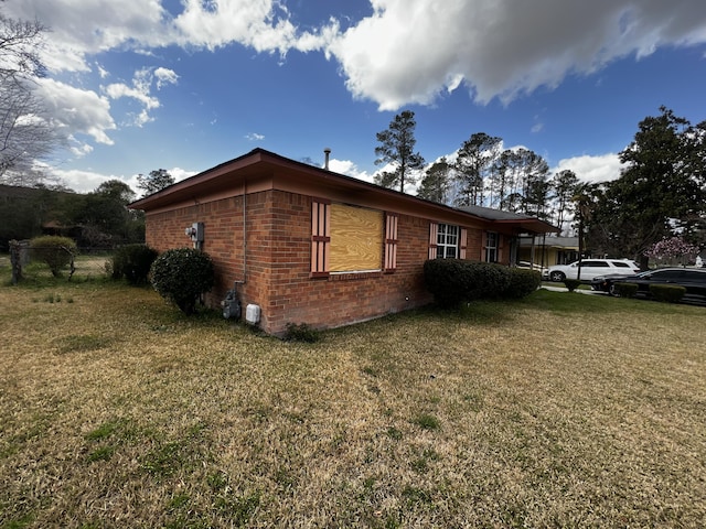 view of property exterior featuring brick siding and a yard