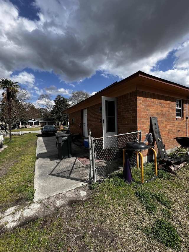 view of home's exterior featuring fence and brick siding