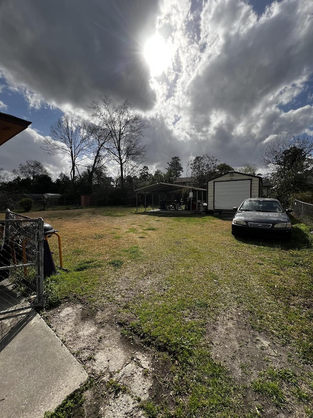 view of yard with a garage and an outbuilding