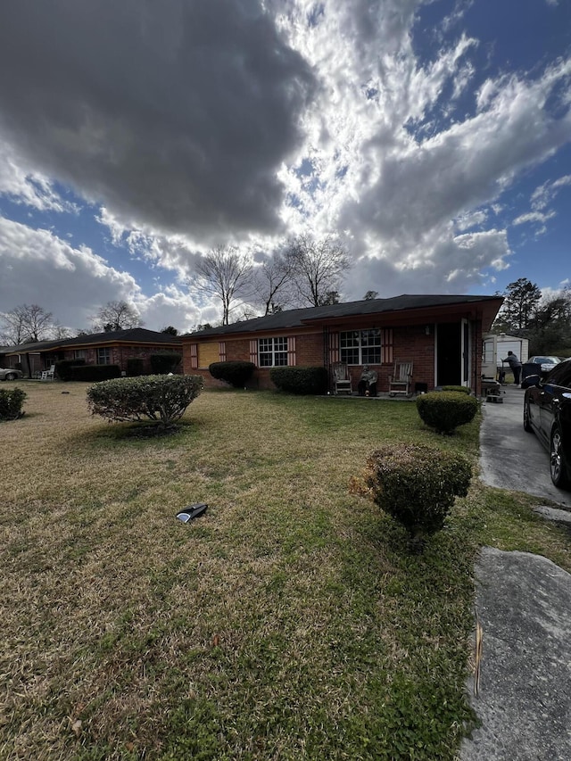 view of front of house featuring a front yard and brick siding