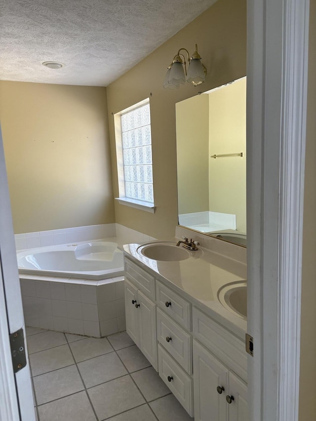 bathroom with double vanity, a sink, a textured ceiling, tile patterned floors, and a bath