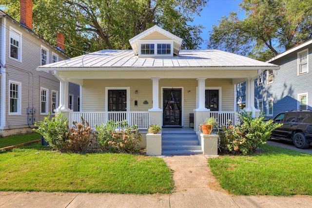 view of front of home featuring covered porch and a front yard