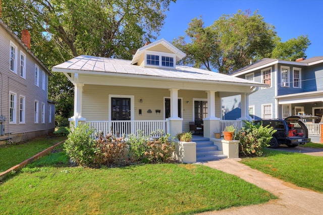 bungalow with a front yard and covered porch