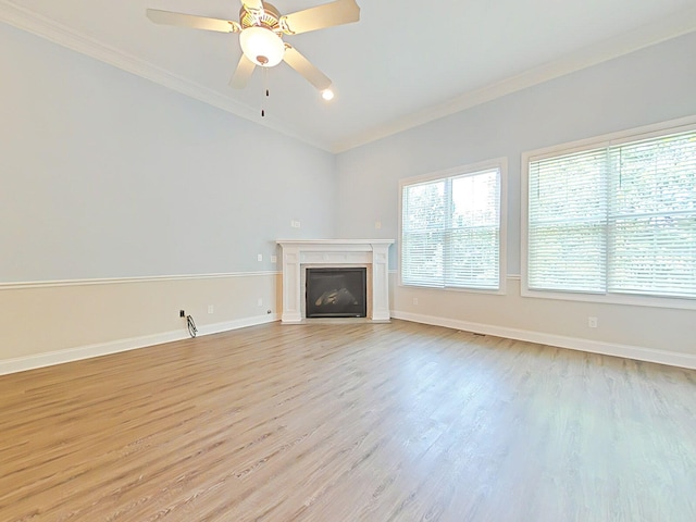 unfurnished living room with baseboards, ornamental molding, light wood-style flooring, and a fireplace with flush hearth