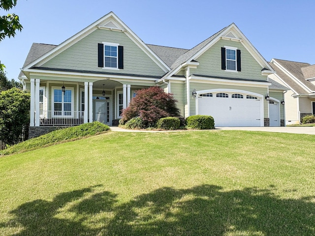 craftsman-style home featuring a porch, a garage, driveway, and a front yard