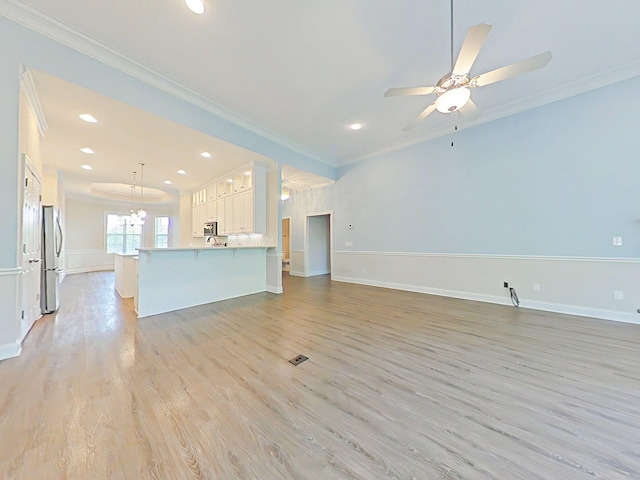 unfurnished living room with recessed lighting, ornamental molding, light wood-style flooring, and baseboards