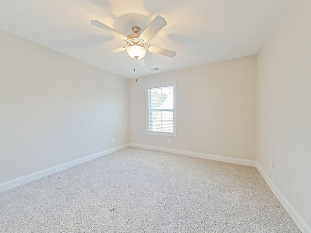 unfurnished room featuring baseboards, ceiling fan, visible vents, and light carpet
