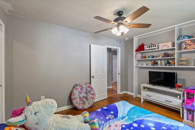 bedroom featuring a ceiling fan, baseboards, and wood finished floors