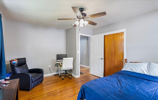 bedroom with ceiling fan, baseboards, and wood finished floors