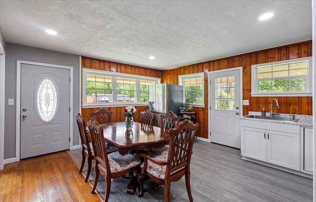 dining room featuring a textured ceiling, baseboards, and wood finished floors