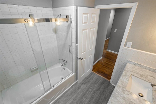 full bath with wood finished floors and bath / shower combo with glass door