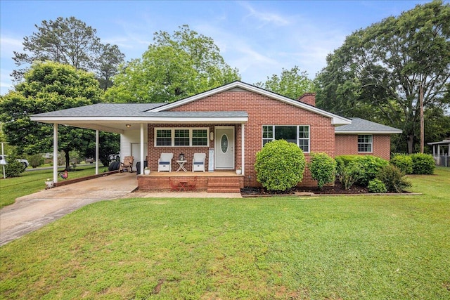 ranch-style home with covered porch, concrete driveway, a front yard, a carport, and brick siding