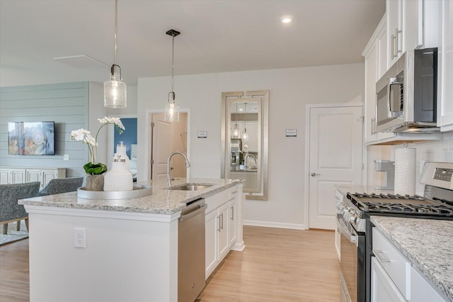 kitchen featuring a kitchen island with sink, white cabinetry, sink, and stainless steel appliances