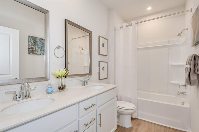 full bathroom featuring hardwood / wood-style floors, shower / bath combo, toilet, and vanity