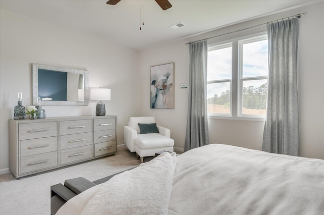 bedroom with multiple windows, ceiling fan, and light carpet