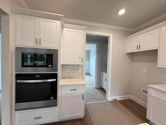 251 Prominence Dr, Grovetown, GA 30813 - kitchen with oven, dark wood-style floors, light countertops, ornamental molding, and built in microwave