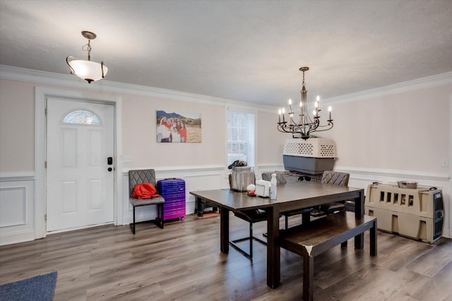 dining room with crown molding, wood-type flooring, and a chandelier