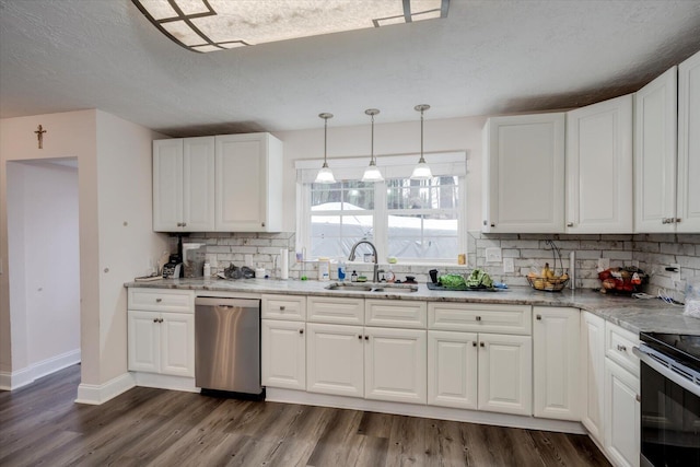 kitchen with appliances with stainless steel finishes, white cabinetry, sink, hanging light fixtures, and light stone countertops