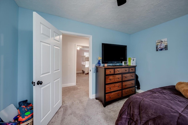 bedroom with light carpet and a textured ceiling