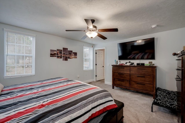 carpeted bedroom with ceiling fan and a textured ceiling