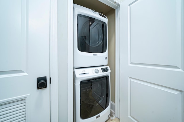 laundry room with stacked washing maching and dryer