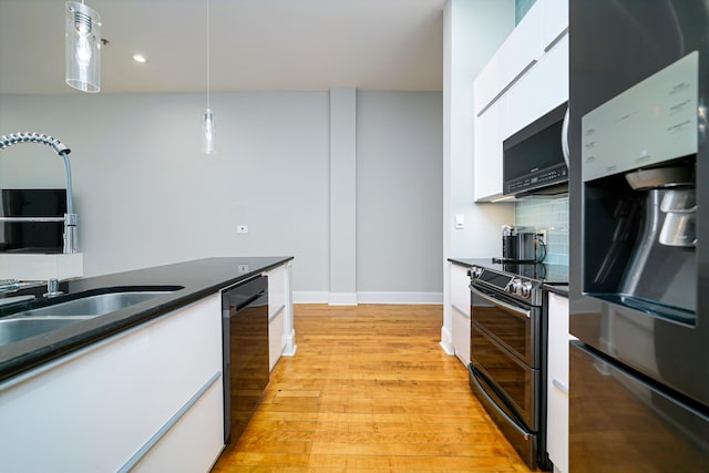 kitchen with black appliances, decorative light fixtures, decorative backsplash, and white cabinetry