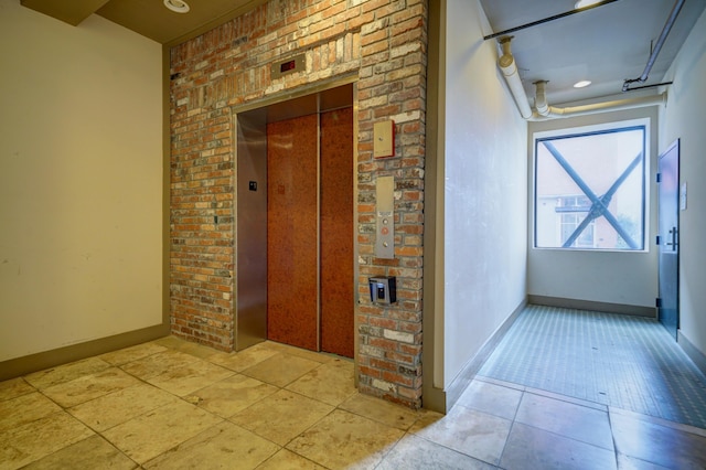 hallway featuring elevator and light tile patterned flooring