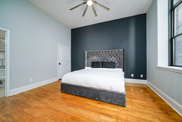 bedroom with connected bathroom, ceiling fan, wood-type flooring, and lofted ceiling