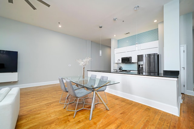 dining area with light hardwood / wood-style flooring, ceiling fan, and sink