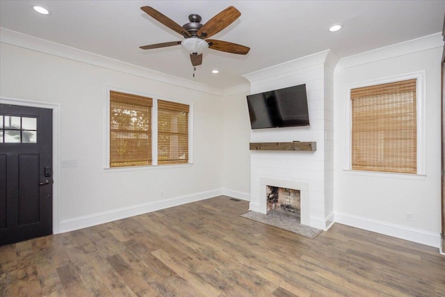 925 Beman St, Augusta, GA 30904 - unfurnished living room featuring a ceiling fan, a large fireplace, crown molding, wood finished floors, and baseboards